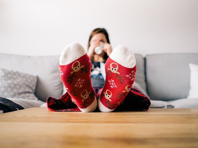 A Woman stays warm and enjoys a cup of cocoa in her cozy house with efficient energy use